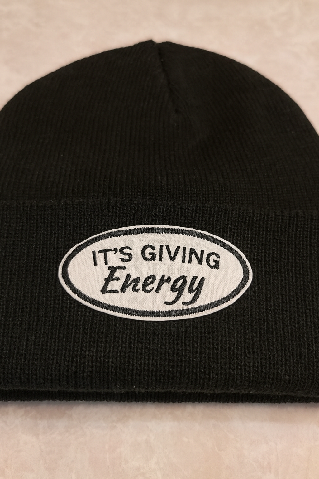 It’s Giving Energy Embroidered Patch – Faux Leather Iron-On/Sew-On Patch on a black cuff knit beanie